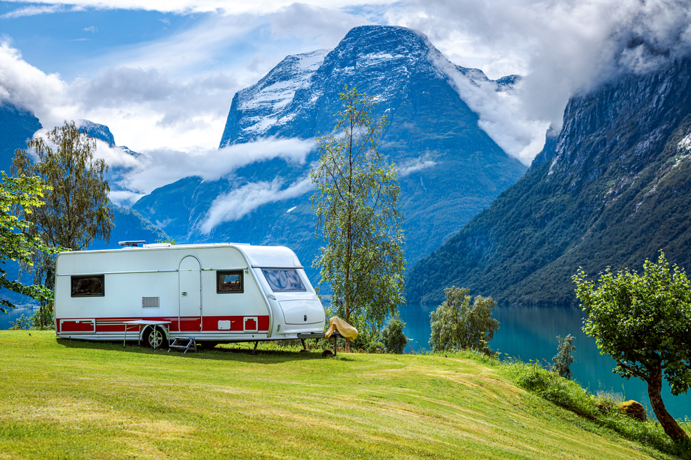 rv on green pasture with mountains in the background